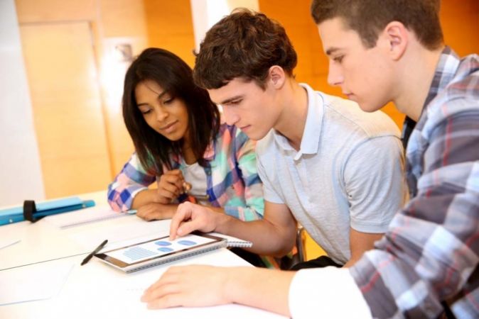 Three students job searching on iPad