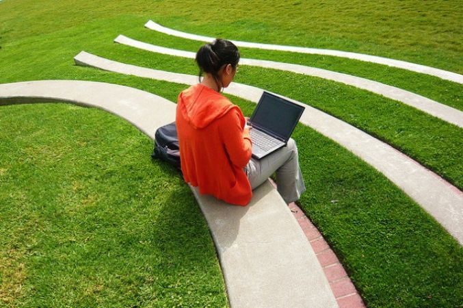 student with laptop sitting outside
