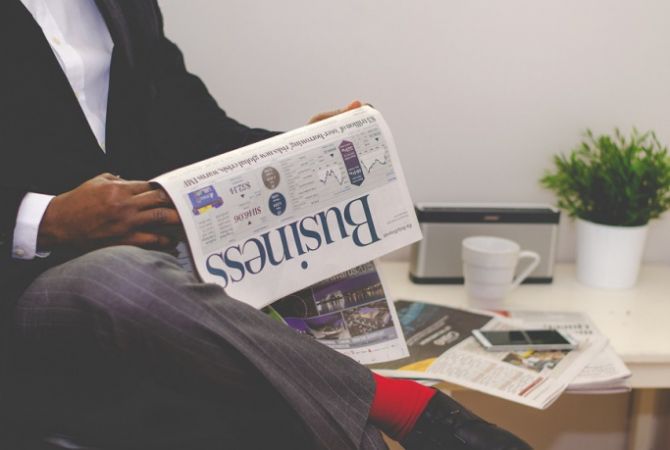 Man in improving his commercial awareness skills by reading a business newspaper