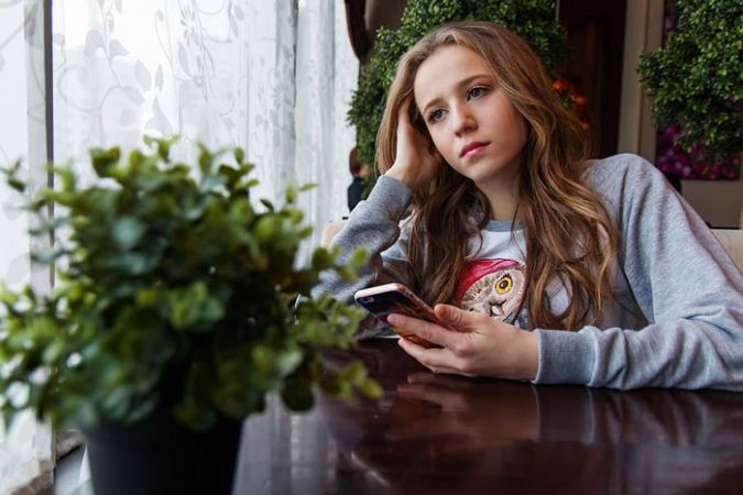Teenage girl sad with phone