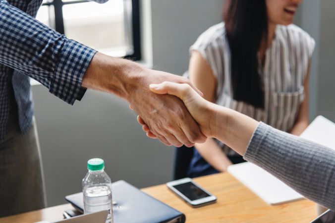 Two people shaking hands in a business meeting